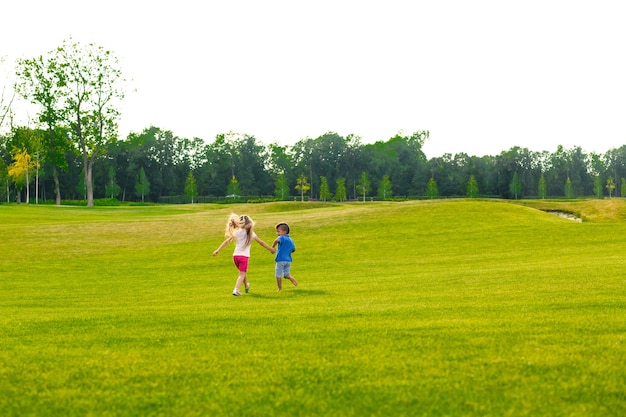 Two children are running and jumping on the glade