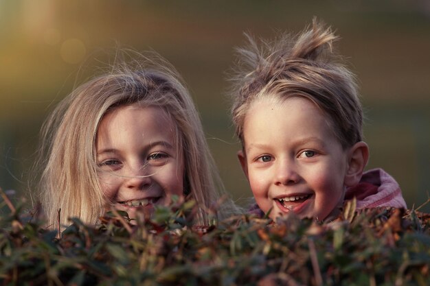 写真 2人の子供が笑顔で1人は赤いシャツを着ています