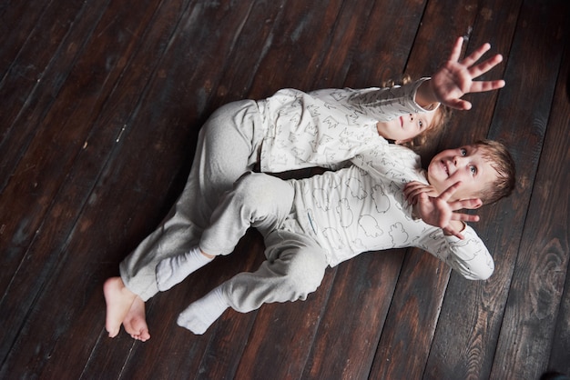 Two children, brother and sister in pajamas play together