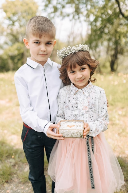 Two children dressed festively present wedding rings for brides