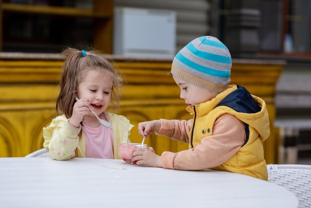 写真 晴れた日に外でアイスクリームを食べる 2 人の子供