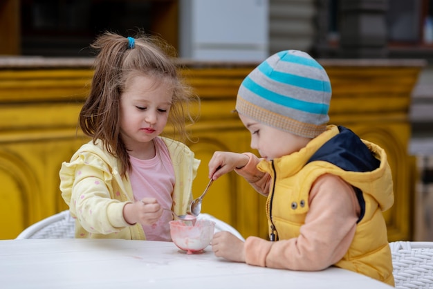 写真 晴れた日に外でアイスクリームを食べる 2 人の子供