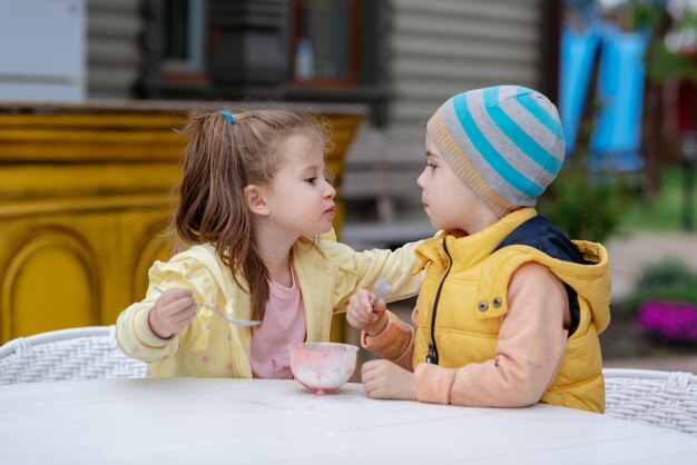 Two children eating ice cream outside on a sunny day