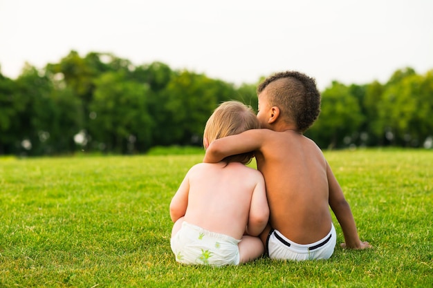 夕方の空き地にいる2人の子供が遊んで、抱き合っています。