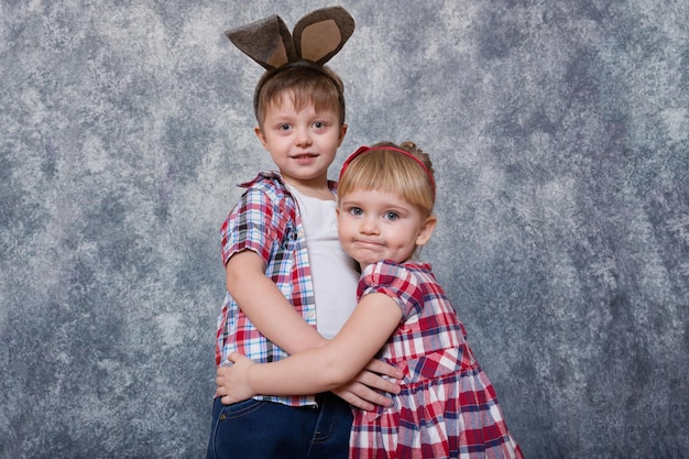 머리에 부활절 토끼 귀를 가진 두 명의 어린이 소녀와 소년이 웃고 가족 부활절 복사 공간을 재생합니다.