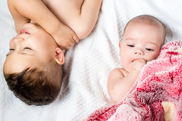 Two children lie on the bed, a view from above