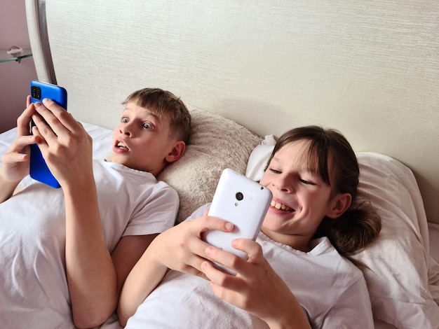 Two children look at smartphone screen in surprise and play online games