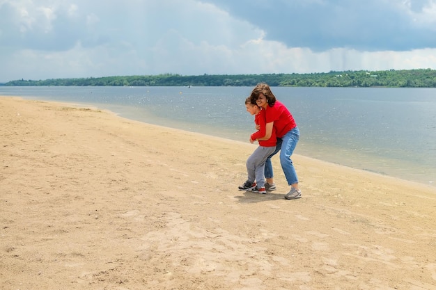 Two children playing on the beach with the water in the background