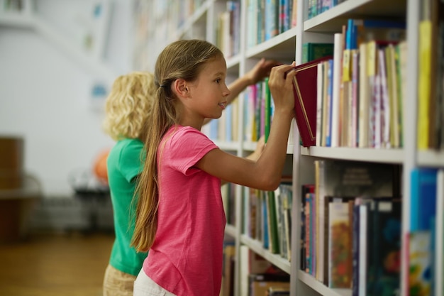 Photo two children selecting educational literature for reading