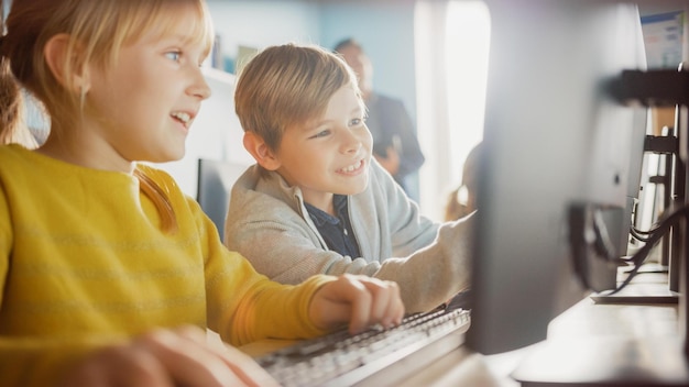 Two children working on a computer in a classroom