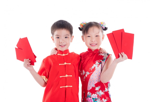 Two chinese children in traditional costume holding red packet money and smile 