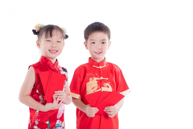 Two chinese children in traditional costume holding red packet money and smile 