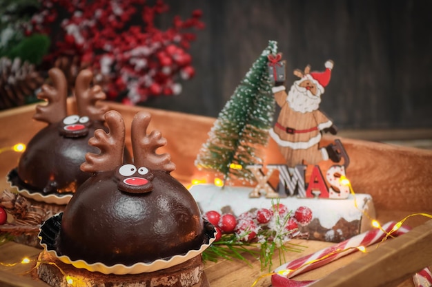 Two chocolate deer in a wooden tray with christmas decor on the table