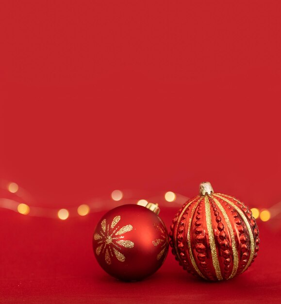 Two Christmas red baubles design in a red background with yellow lights bokeh