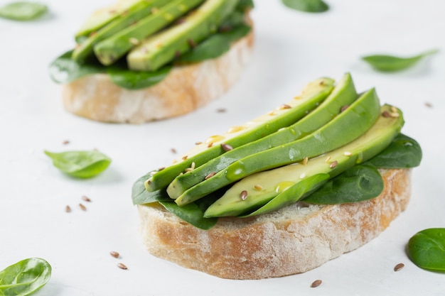 Two ciabatta toast with sliced avocado olive oil