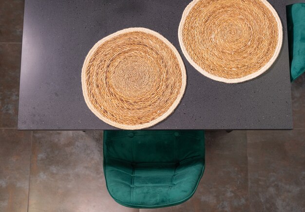 Two circular woven straw placemats on a kitchen table