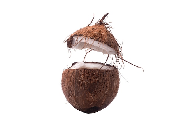 Две половинки кокосового ореха, изолированные на белом фоне, одна сломана пополам