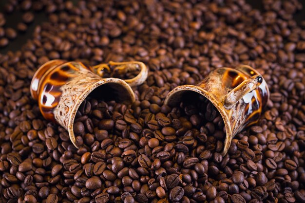 Two coffee cups full of roasted coffee beans. Beautiful coffee background.