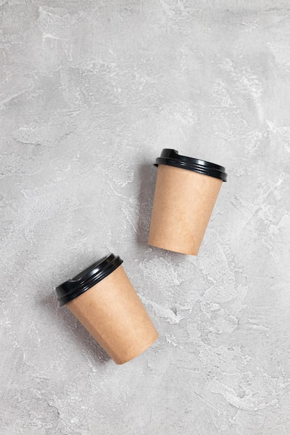 Two coffee kraft paper cups mockup on a gray concrete background