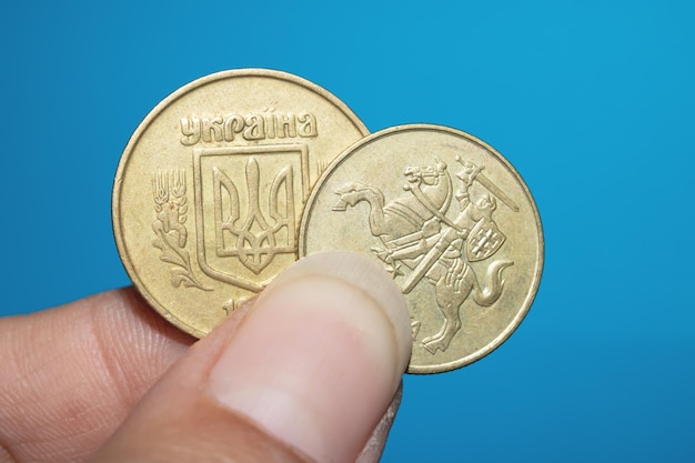 Two coins in hand on blue background