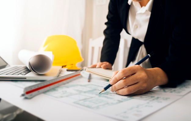 Two colleagues discussing data working and tablet laptop with on on architectural project at construction site at desk in office