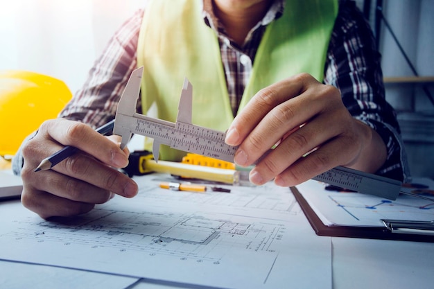 Two colleagues discussing data working and tablet laptop with\
on on architectural project at construction site at desk in\
office