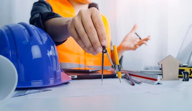 Two colleagues discussing data working and tablet laptop with\
on on architectural project at construction site at desk in\
office