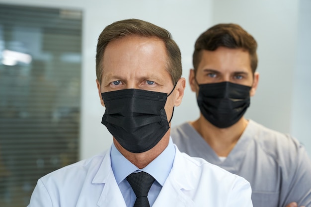 Two colleagues at medical clinic posing in masks