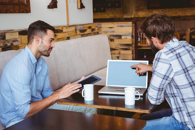 ラップトップとタブレットを扱う2人の同僚