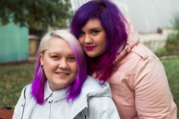 two color hair lesbian holding hands and smiling happy homosexual couple outdoor