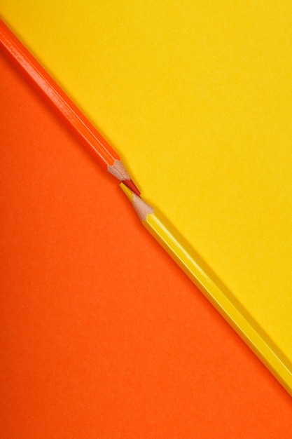 두 개의 서로 다른 색 종이 배경에 고립 된 두 개의 색연필