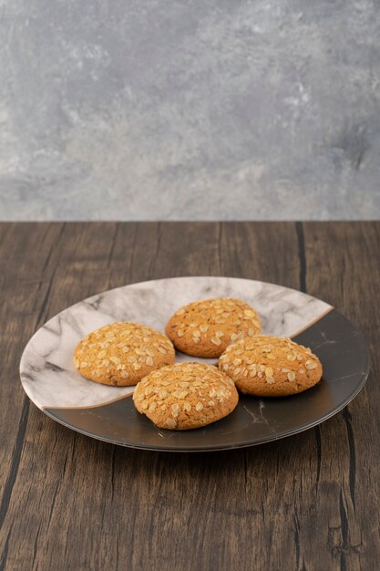 Two colored plate of oatmeal cookies on wooden surface. 