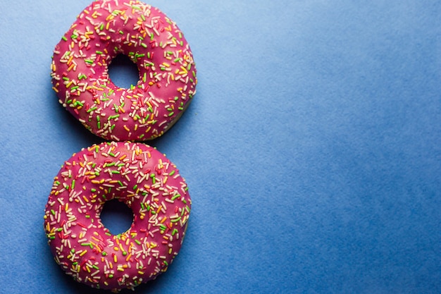 Two colorful donuts on blue background