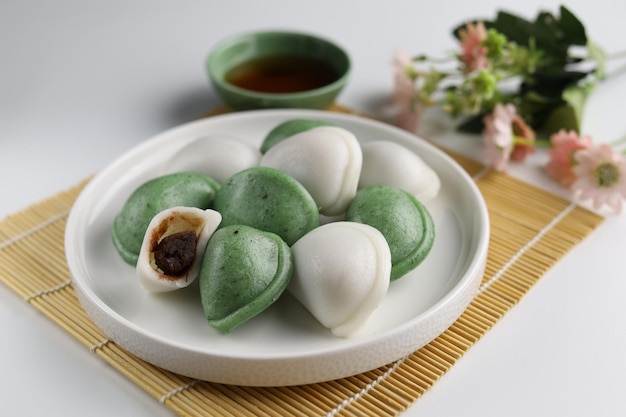 Photo two colors of songpyeon halfmoonshaped rice cake served in the white plate