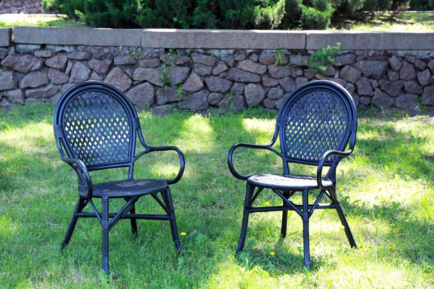 Two comfortable chairs on green grass in park