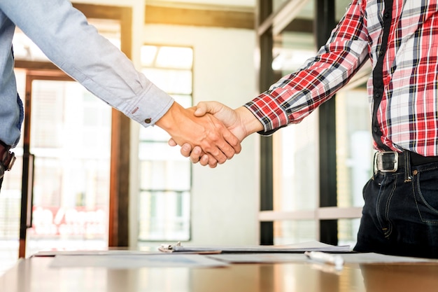 Two confident business man shaking hands during a meeting in the office