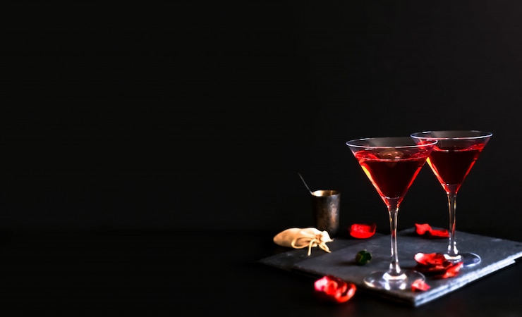 Two cosmopolitan cocktails in a triangular glass