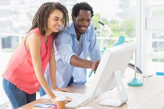 Two creative business colleagues discussing over a computer