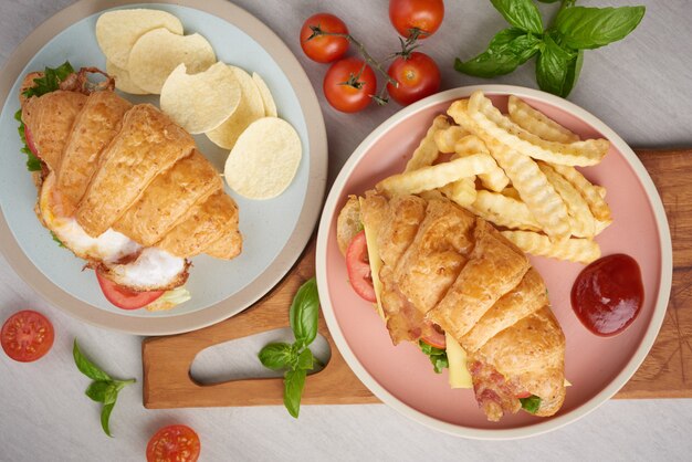 Two croissant sandwiches on wooden table, top view