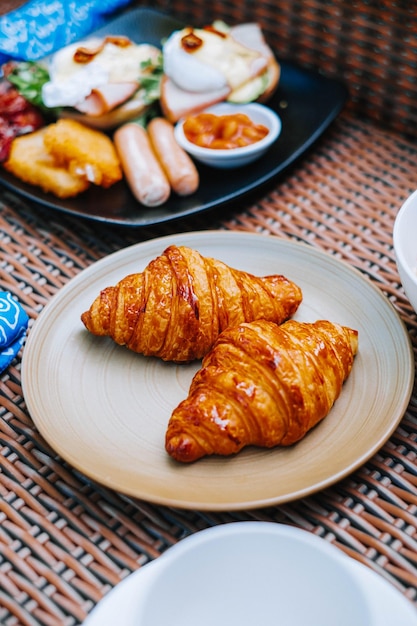 2 つのクロワッサンが背景をぼかした茶色のプレートに配置されます。