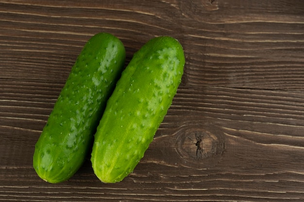 Two cucumbers in closeup on a wooden background And a place for the inscription