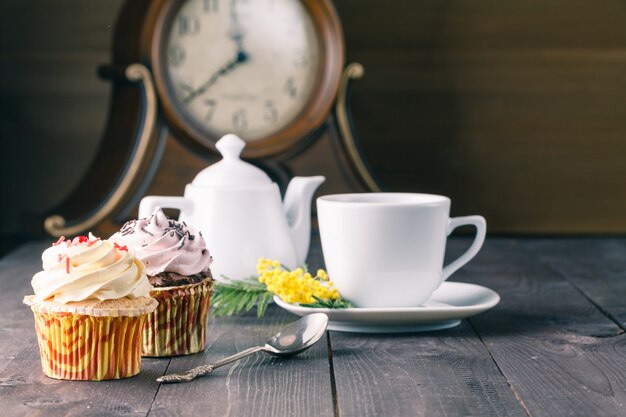 Photo two cupcakes on dark wooden table