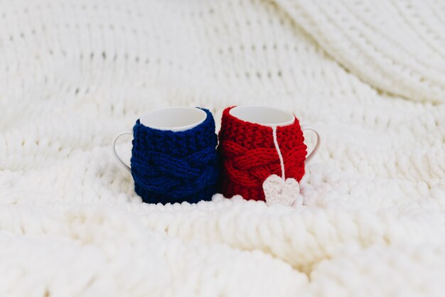 Two cups, blue and red, isolated on blanket for Valentines day