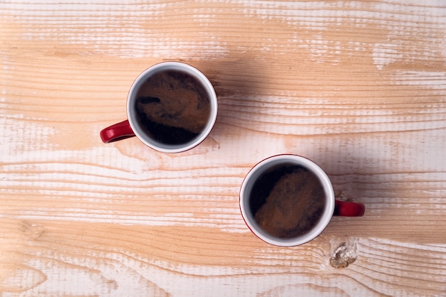 明るい茶色のテーブルの上のコーヒー2杯。真上