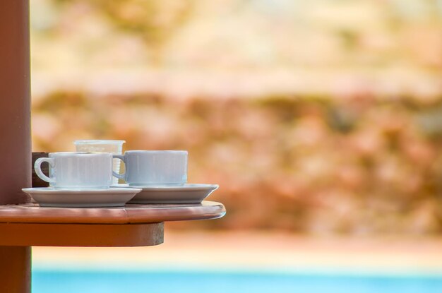 Two cups of coffee on the table near the pool