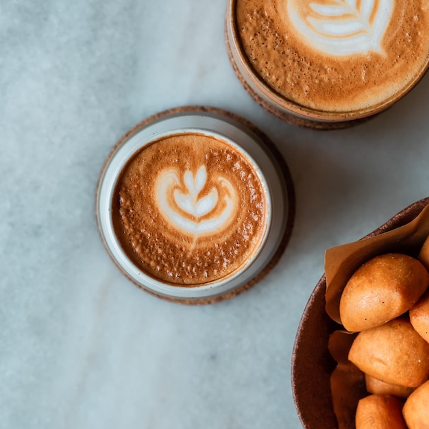 Photo two cups of coffee with a latte art on the top.