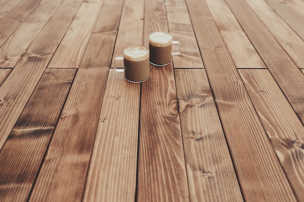 Two cups of coffee in the wooden brown terrace background. High quality photo