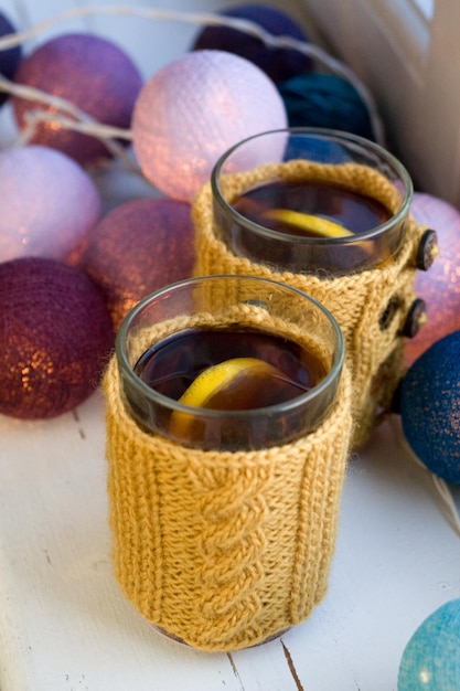 Two cups of delicious tea in yellow knitted sweater