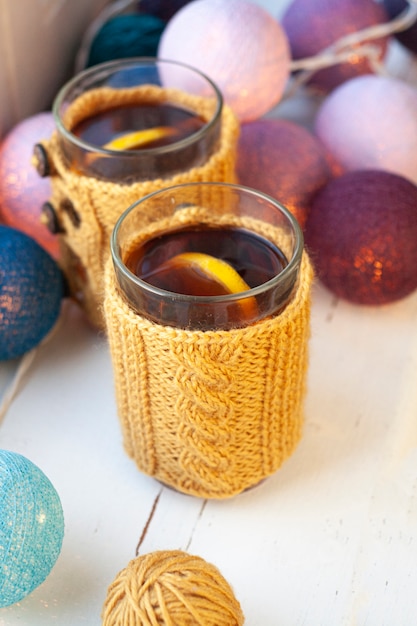 Two cups of delicious tea in yellow knitted sweater	