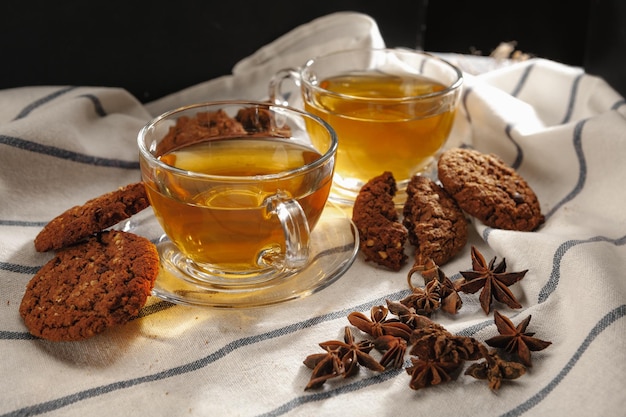 Two cups of herbal tea and cookies on kitchen cloth